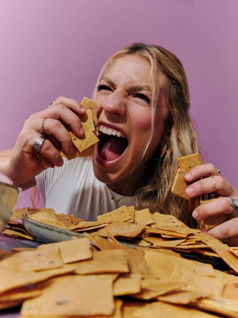 Rindo ao telefone com prato de chips